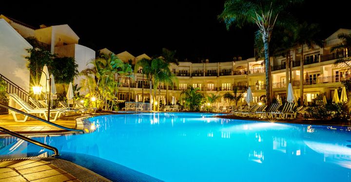 Luxury resort with illuminated pool at night