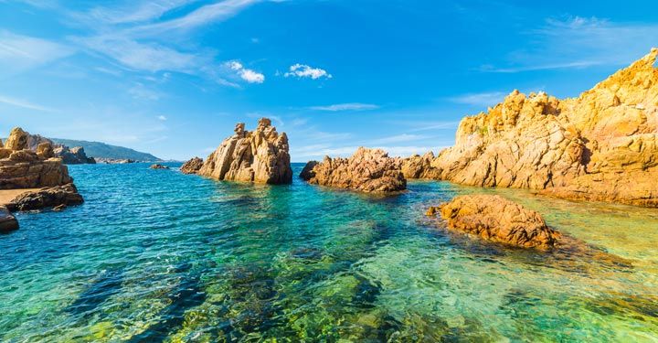 Turquoise colored crystal clear water at a rocky island